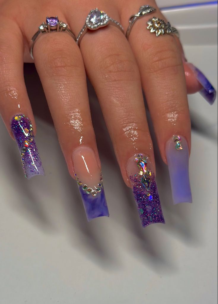 Chic Gradient Purple Nail Design with Glitter and Iridescent Gems on Long Acrylics.