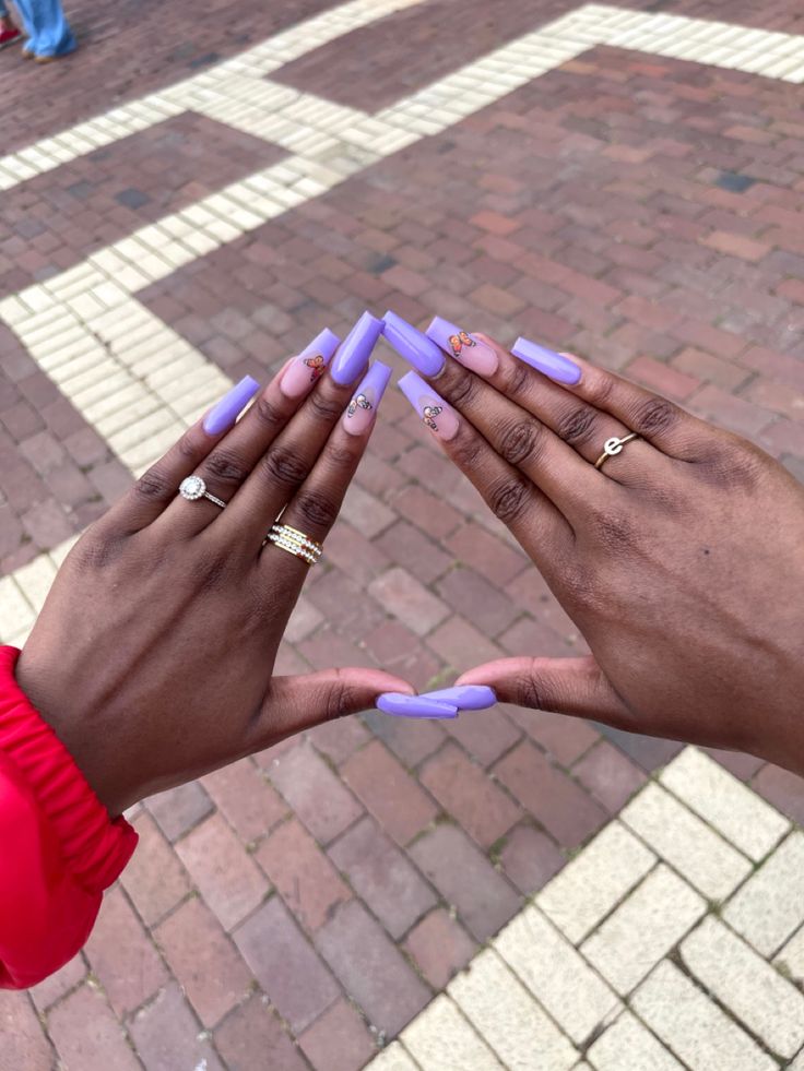 Chic Lavender and Pastel Pink Almond-shaped Nail Design with Floral Patterns and Sparkling Accents.