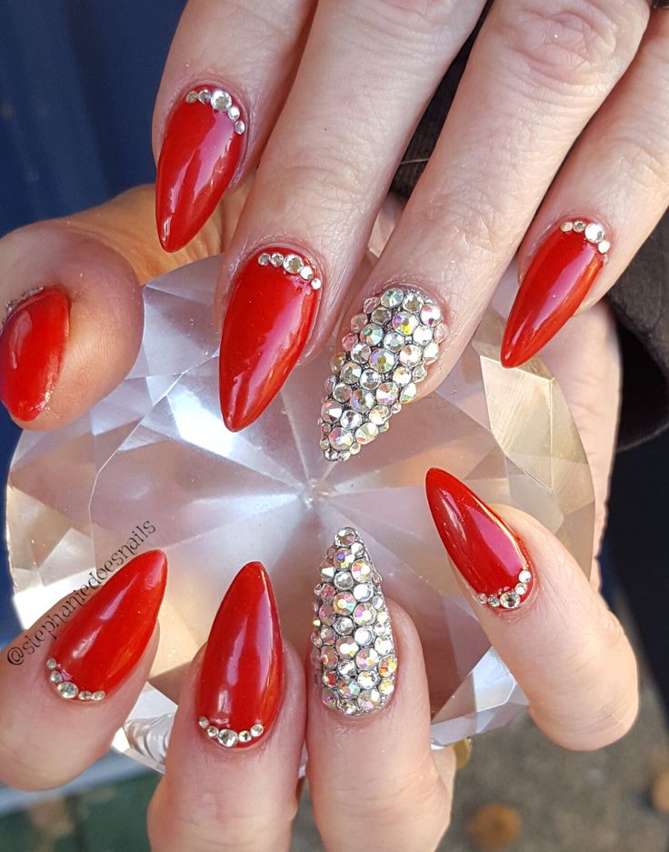 Glamorous Red Almond-Shaped Nails Embellished with Shimmering Rhinestones for a Bold Statement.