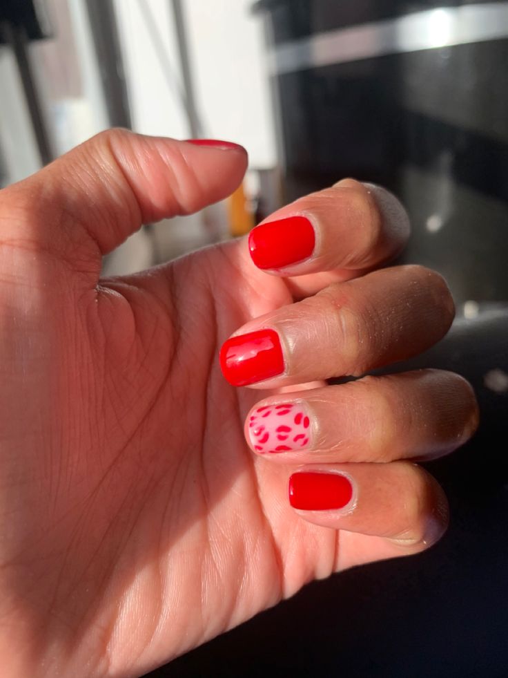 Bold Red Nails with Trendy Pink Leopard Accent Design for a Stylish Look.