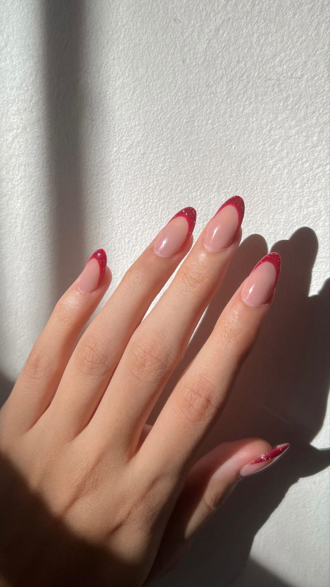 Chic Almond-Shaped Nails with Nude Base and Dazzling Red Glitter French Tips