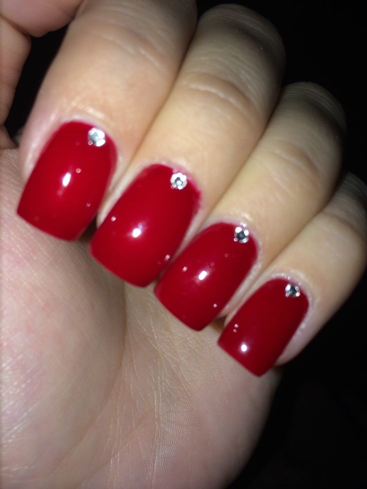 Sophisticated Red Nail Design with Glossy Finish and Sparkling Rhinestones.