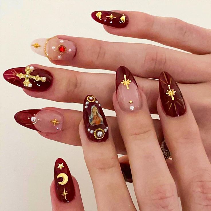 Chic Deep Burgundy Nail Design with Gold Accents and Unique Charms for Stylish Occasions.