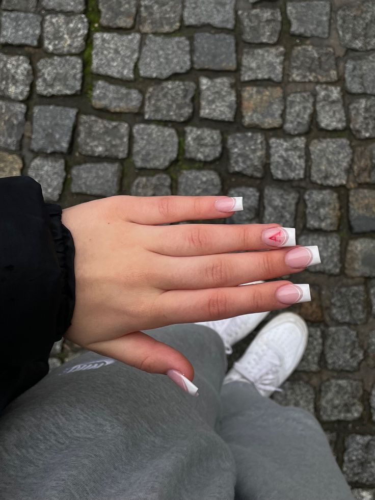 Elegant French Manicure with Heart Detail: A Perfect Blend of Sophistication and Fun.