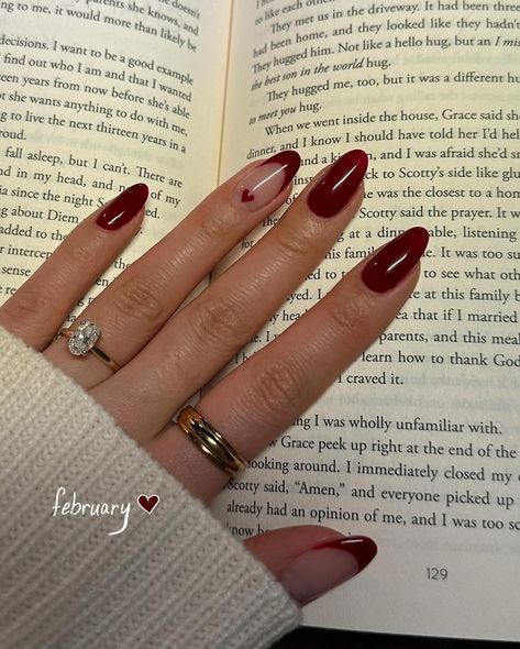 Romantic Deep Red Nail Design with Playful Heart Accents for February.