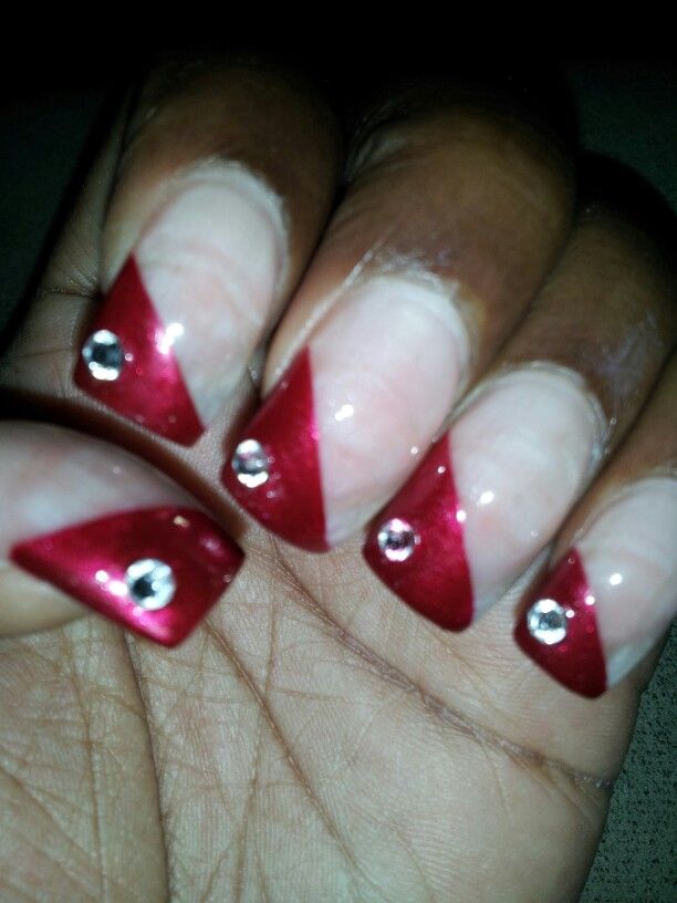 Chic Bold Diagonal Nail Design with Nude Base and Vibrant Red Tips Enhanced by Sparkling Rhinestones.