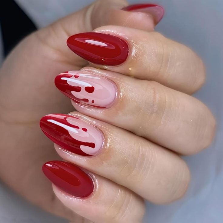 Bold Glossy Red and Nude Nail Design with Artistic Dripping Patterns.