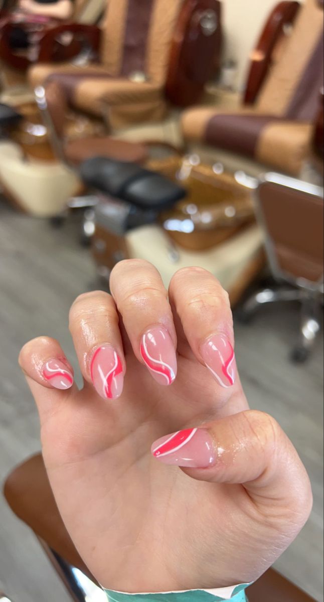 Chic Almond-Shaped Pink Nails with Elegant White Swirls.