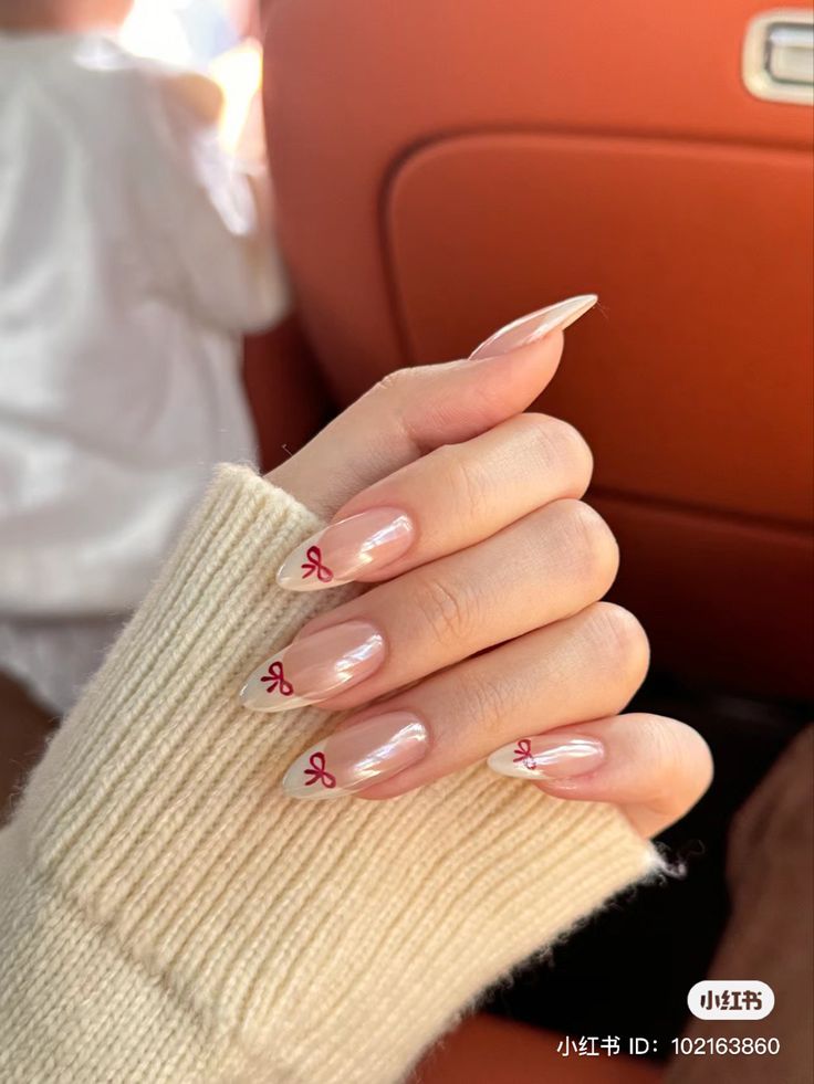 Elegant Nude Nail Design with White Tips and Charming Red Bow Accents