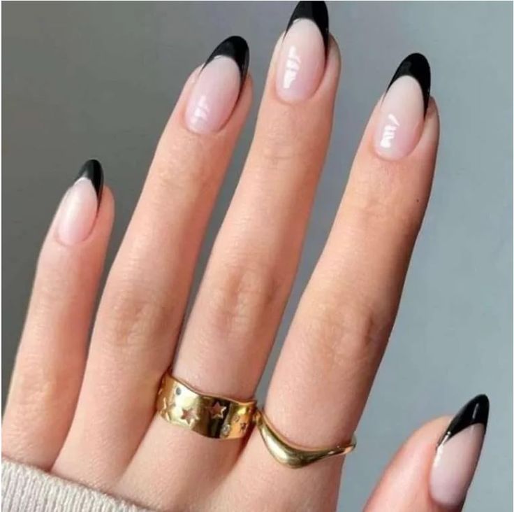 Chic Ombre Nail Design: Soft Pink Base with Bold Black Tips and Elegant Gold Accents.