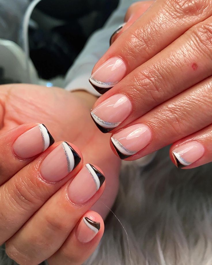 Chic Nude and Black French Tip Nails with Silver Accents.