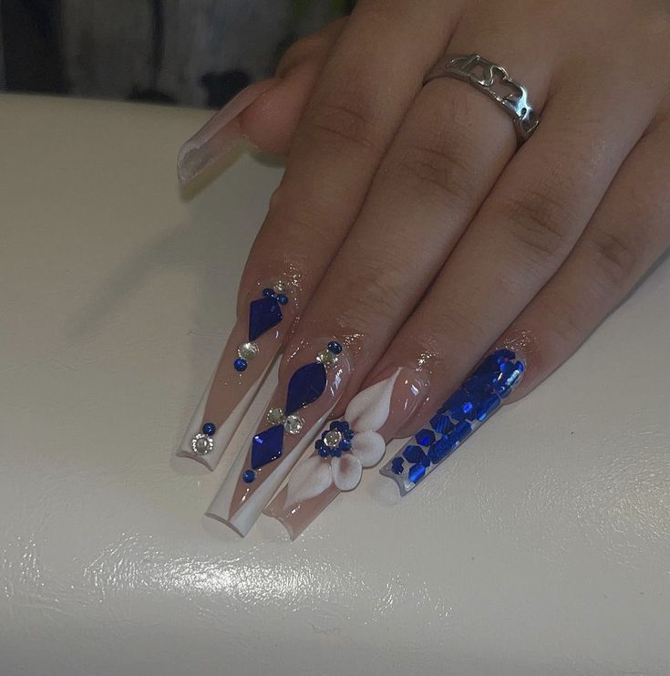 Elegant Blue and White Nail Art with Intricate Designs and Sparkling Embellishments.