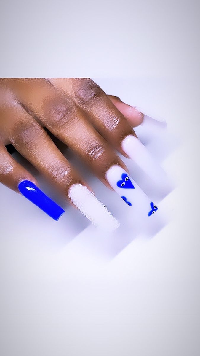 Playful Vibrant Blue and Crisp White Nail Design with Charming Decorative Motifs.