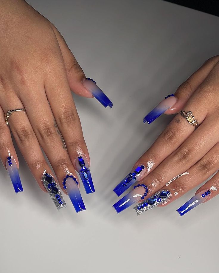 Striking Ombre Nail Design with Vibrant Blue Hues and Glamorous Embellishments