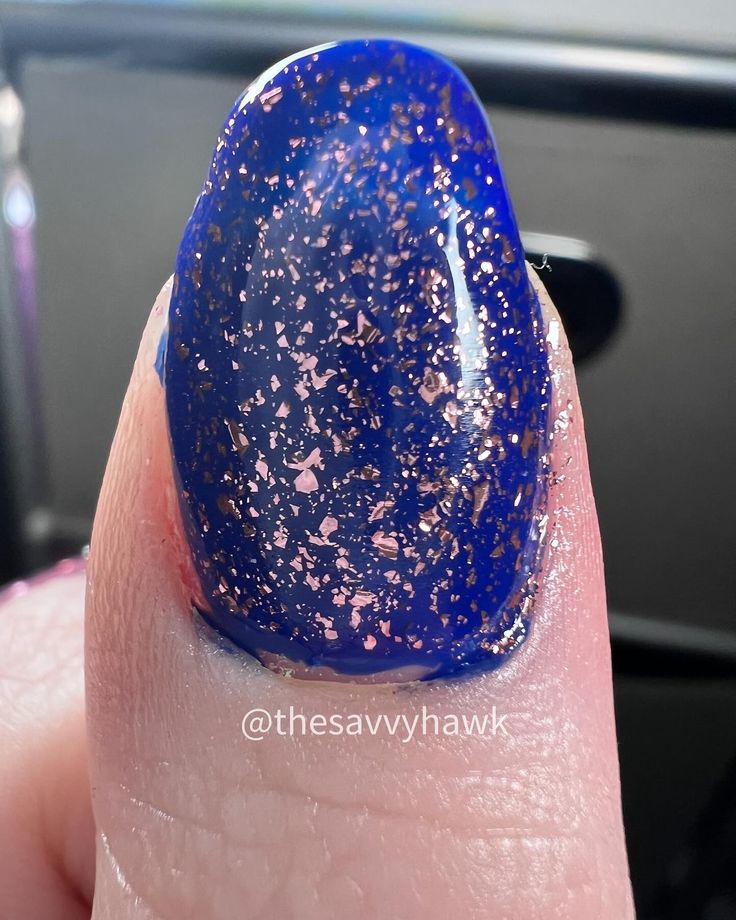 Chic Blue Nail Design with Shimmering Rose Gold Flakes for a Striking Elegance.