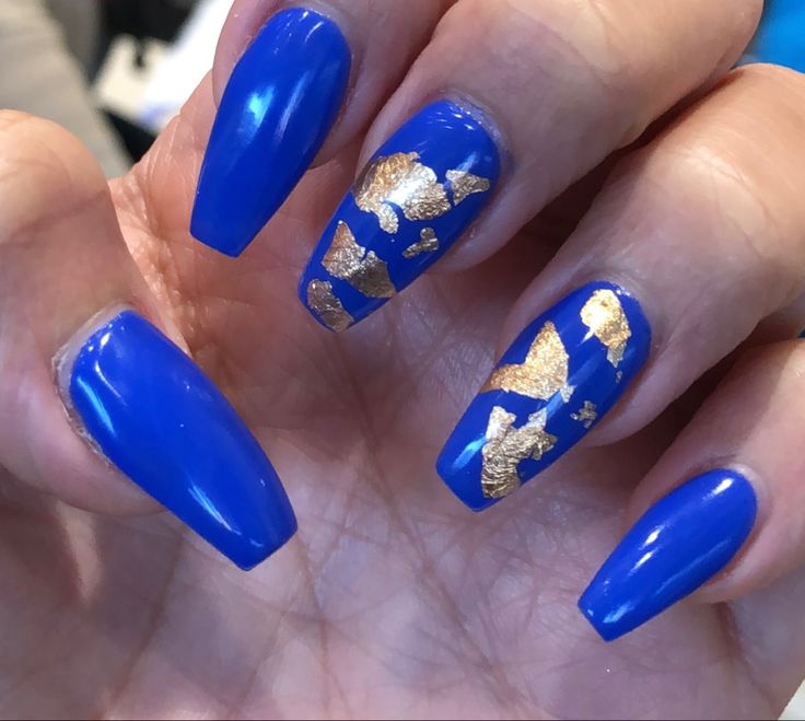 Bold Blue Nails with Elegant Gold Leaf Accents for a Glamorous Look