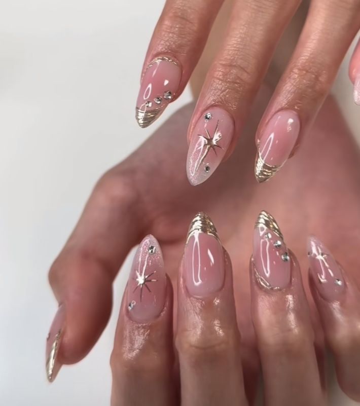 Elegant Almond-Shaped Nail Design with Golden French Tips and Glamorous Rhinestones.