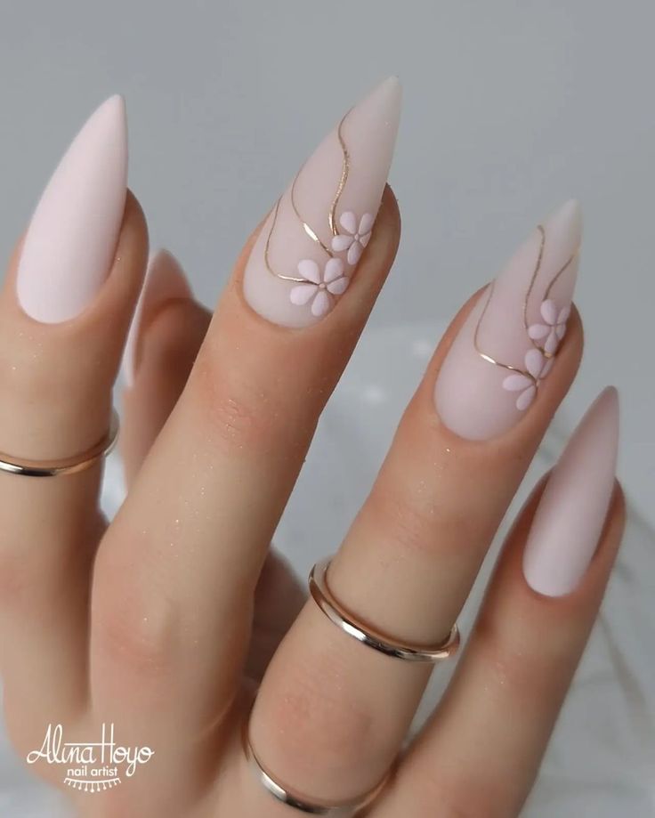 Soft Pink Matte Nail Design with Floral Embellishments and Elegant Gold Accents.