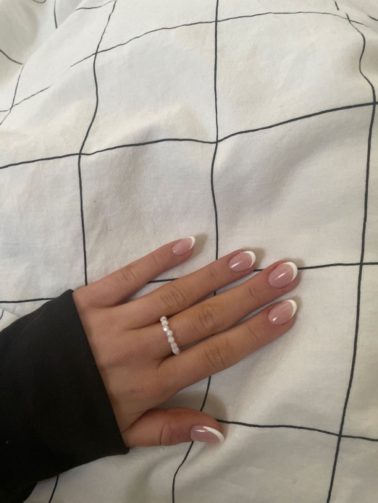 Chic French Manicure with Soft Pink Base and Crisp White Tips Enhanced by a Delicate Ring.