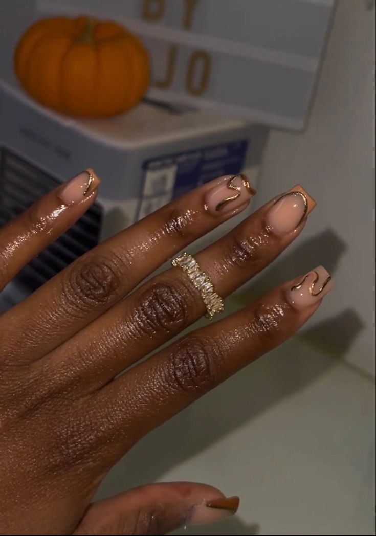 Sophisticated Nude Nail Design with Delicate Gold Accents and Sparkling Ring.