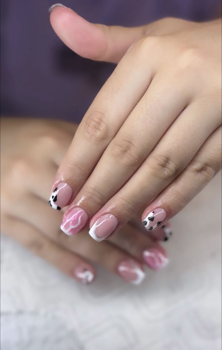 Chic Nail Design: Soft Pink Tones with Elegant White Tips and Playful Black Spots.