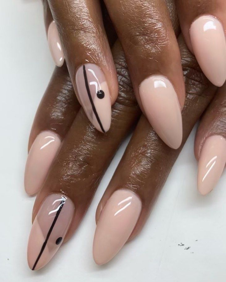 Chic Almond-Shaped Nails Featuring a Nude Base with Stylish Black Accents.