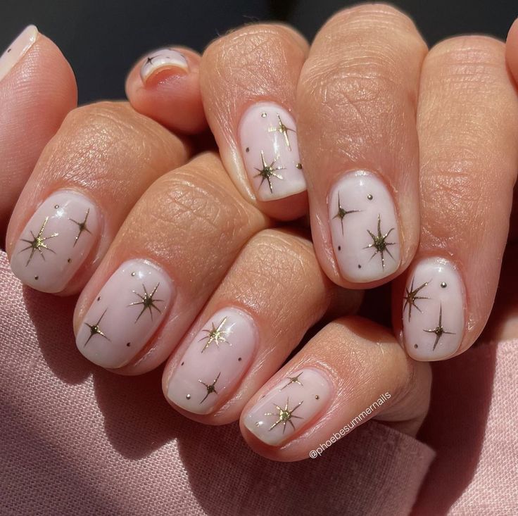 Elegant Starry Nail Design with Soft Nude Base and Delicate Gold Accents.