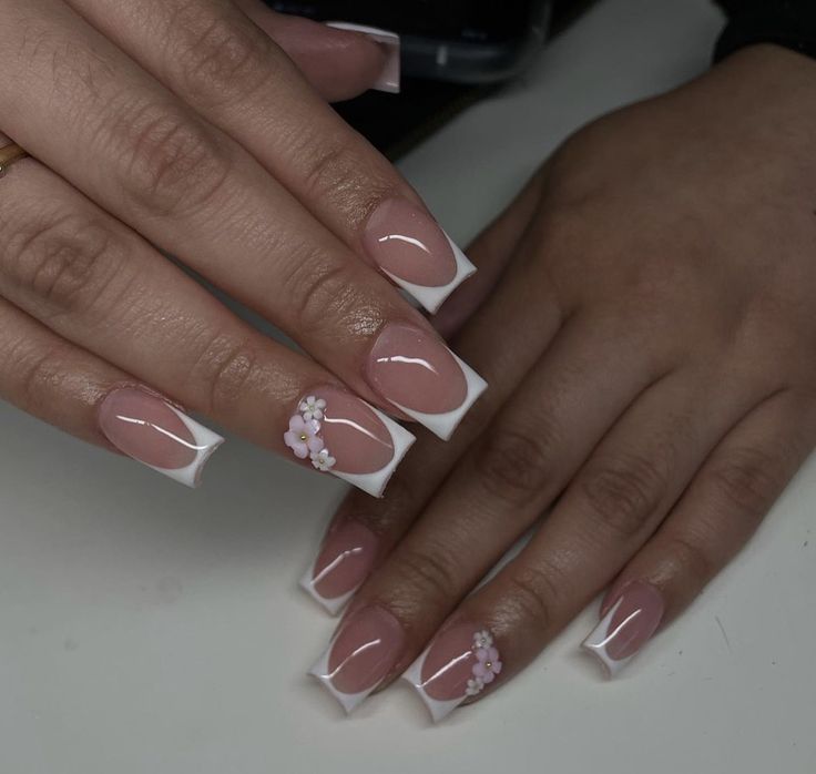 Elegant Nude Acrylic Nails with White French Tips and Floral Accents.