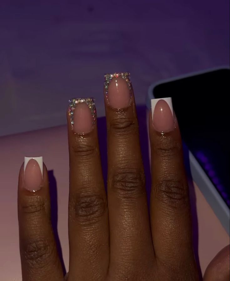 Sophisticated French Manicure with Nude and White Tips Enhanced by Shimmering Rhinestones.