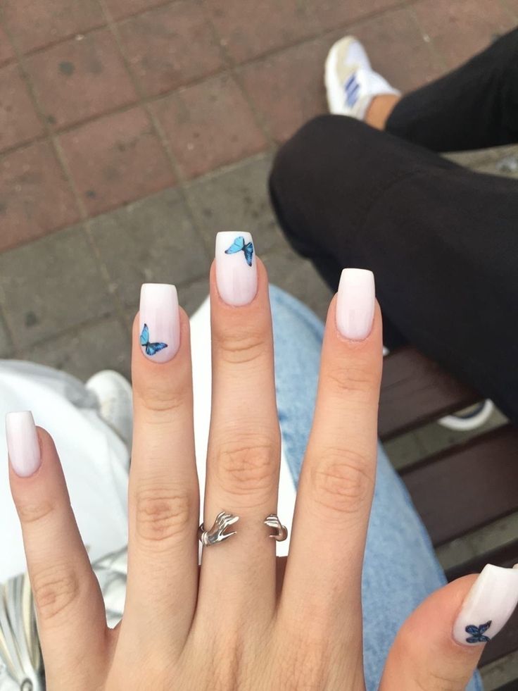 Chic Glossy Pale Pink Nails with Intricate Blue Butterfly Accents for Versatile Elegance and Whimsy.