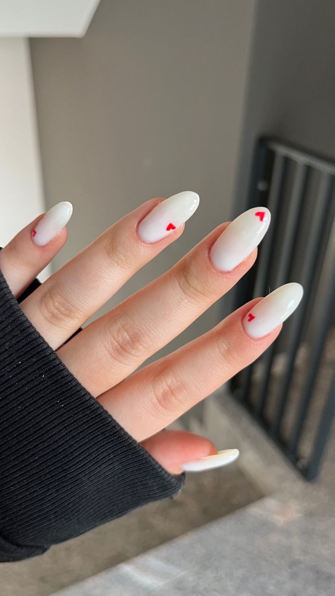 Playful Chic Nail Design: Elegant Almond-Shaped Nails with Romantic Red Heart Tips