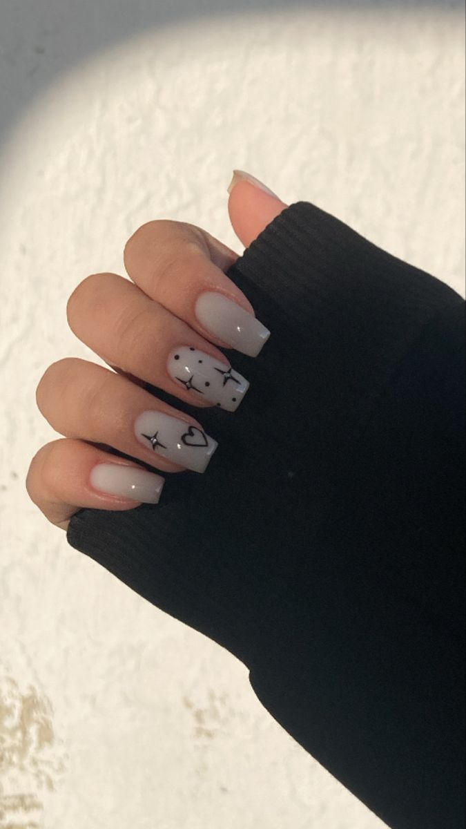 Chic Nail Design: Soft Nude Base with Whimsical Black Line Art Patterns.