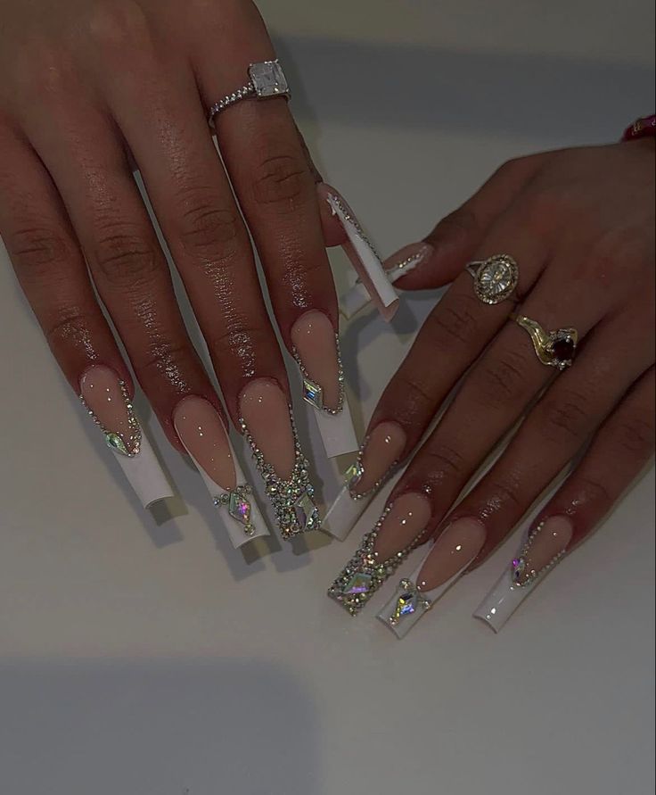 Elegant Long Glossy Acrylic Nail Design with Nude and White Tips Enhanced by Rhinestone Embellishments.