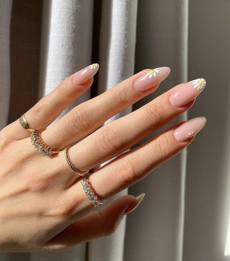 Sophisticated Almond-Shaped Nude Nails with Delicate White Floral Accents.