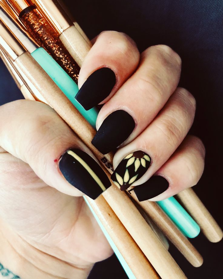 Elegant Black Matte Nails with Unique Foliage and Sleek Accents.