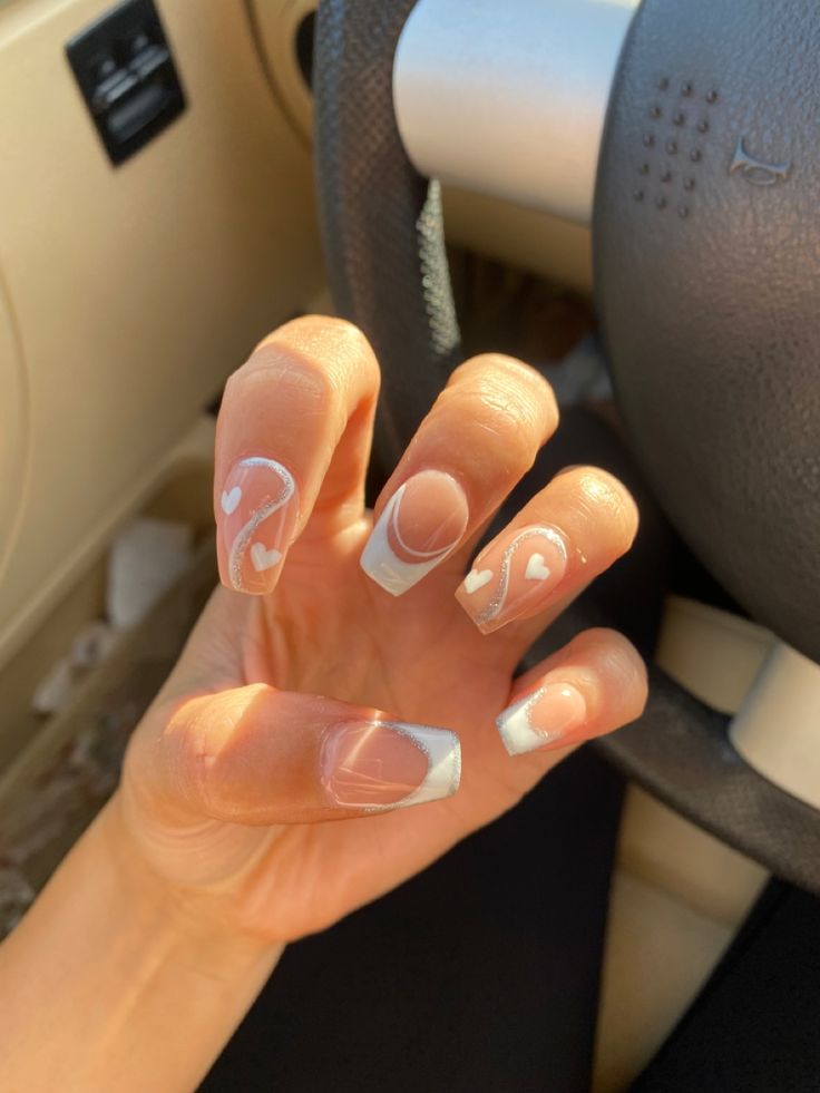 Chic French Tip Nail Design with Whimsical Heart Accents for a Romantic Touch.