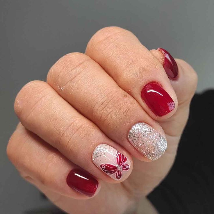 Chic Deep Red and Glitter Nail Design with Playful Butterfly Accent and Eye-Catching Finish Contrast.