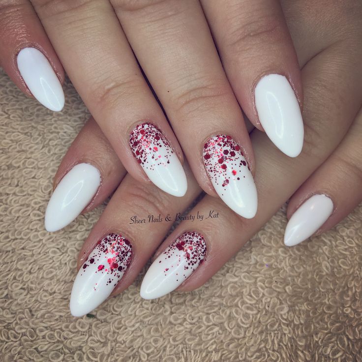 Glossy White Almond-Shaped Nails Enhanced with Playful Red Glitter Accents