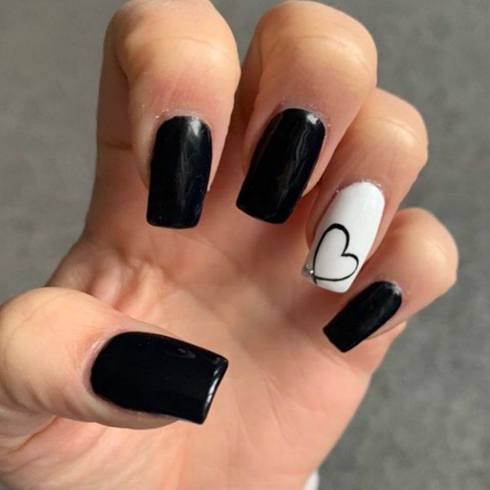 Chic Black and White Matte Nail Design with Playful Heart Accent.