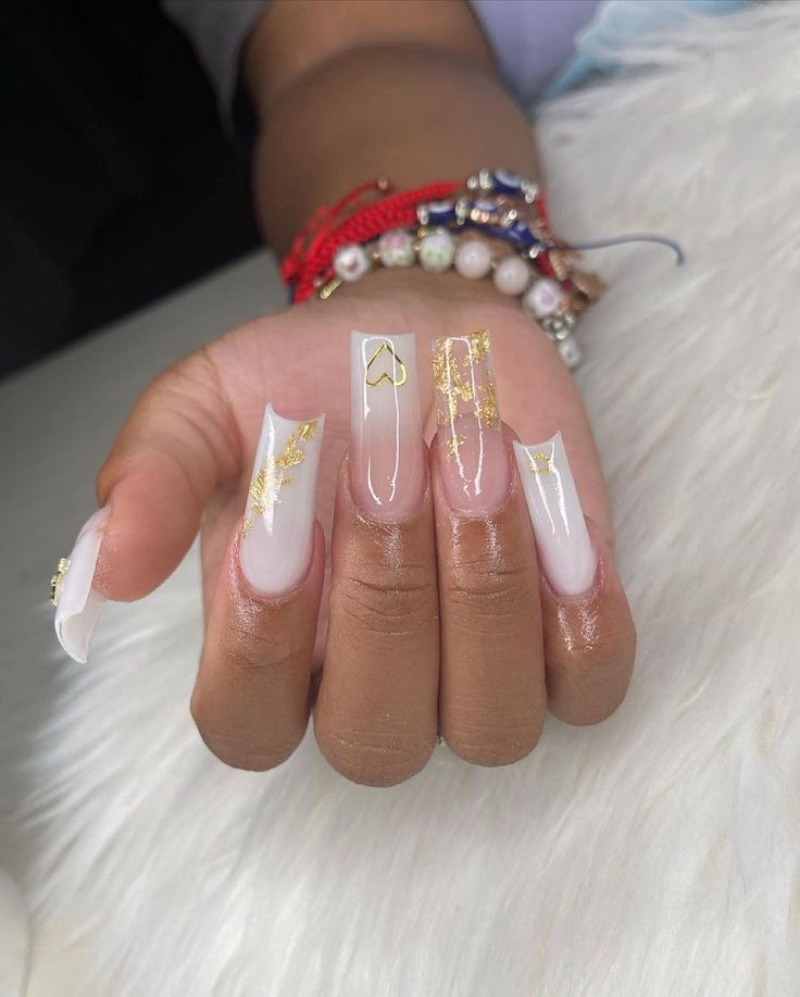 Chic Elegant Nail Design: Glossy Nude Base with Intricate Gold Accents and Square Tips.