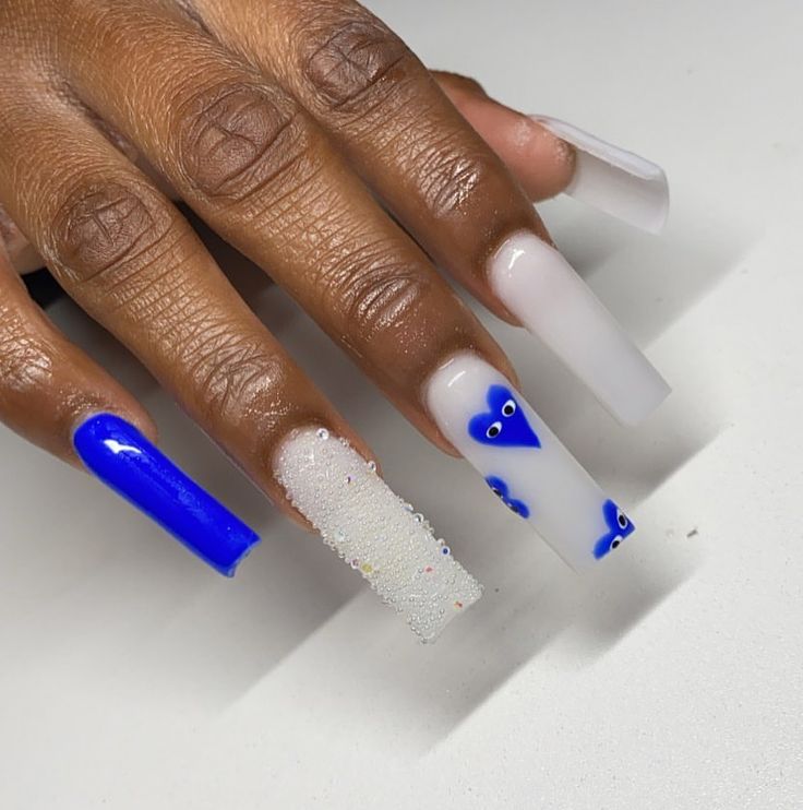 Trendy Nail Design: Bold Blue and Shimmering White with Playful Heart Motifs and Textured Accents.