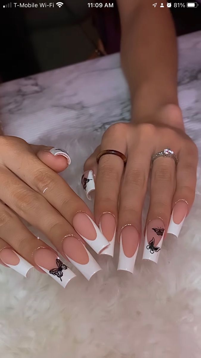 Chic French Tip Nail Design with Delicate Black Butterflies on a Soft Nude Base.