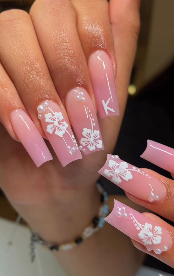 Elegant Floral Nail Design with Delicate White Flowers and Pearl Accents on Soft Pink Background