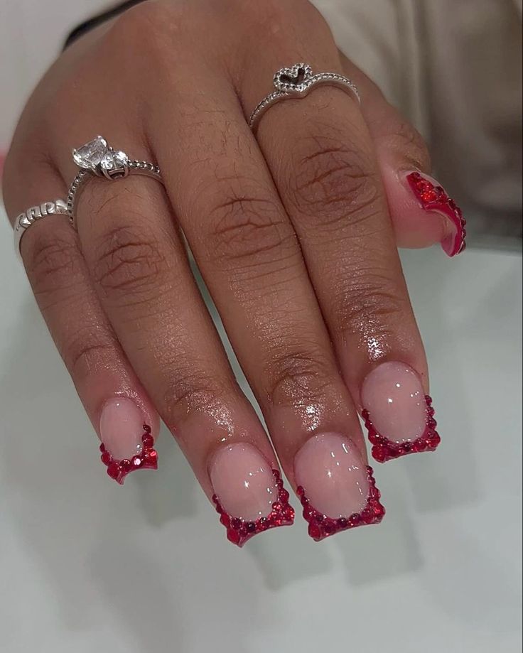 Chic Nude Nails with Bold Red Tips and Glamorous Rhinestone Accents