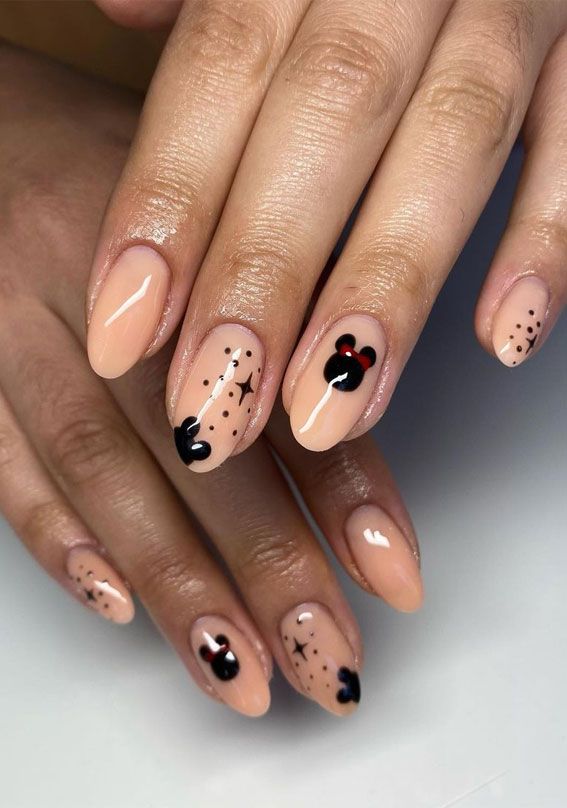 Stylish Nude Nail Design with Playful Black and Red Accents