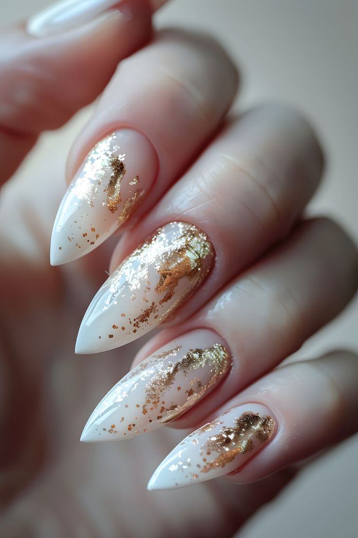 Elegant Almond-Shaped Nail Art with White Base and Shimmering Gold Ombre Glitter Accents.