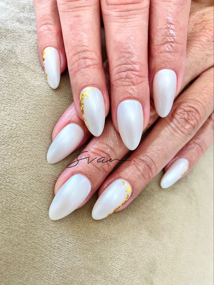 Sophisticated Almond-Shaped Nails with Creamy White Base and Elegant Gold Accents.