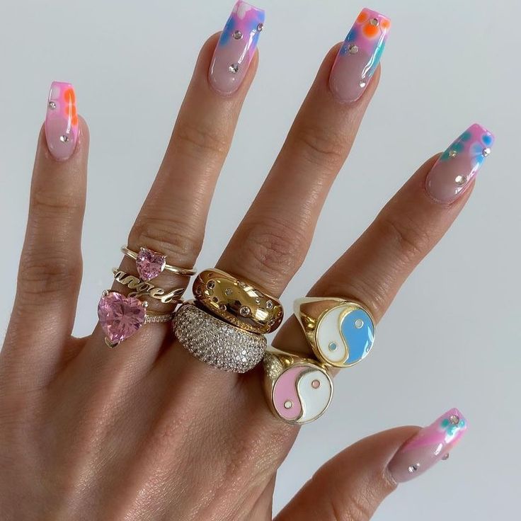 Vibrant Gradient Nail Design with Playful Dots and Glamorous Rings.