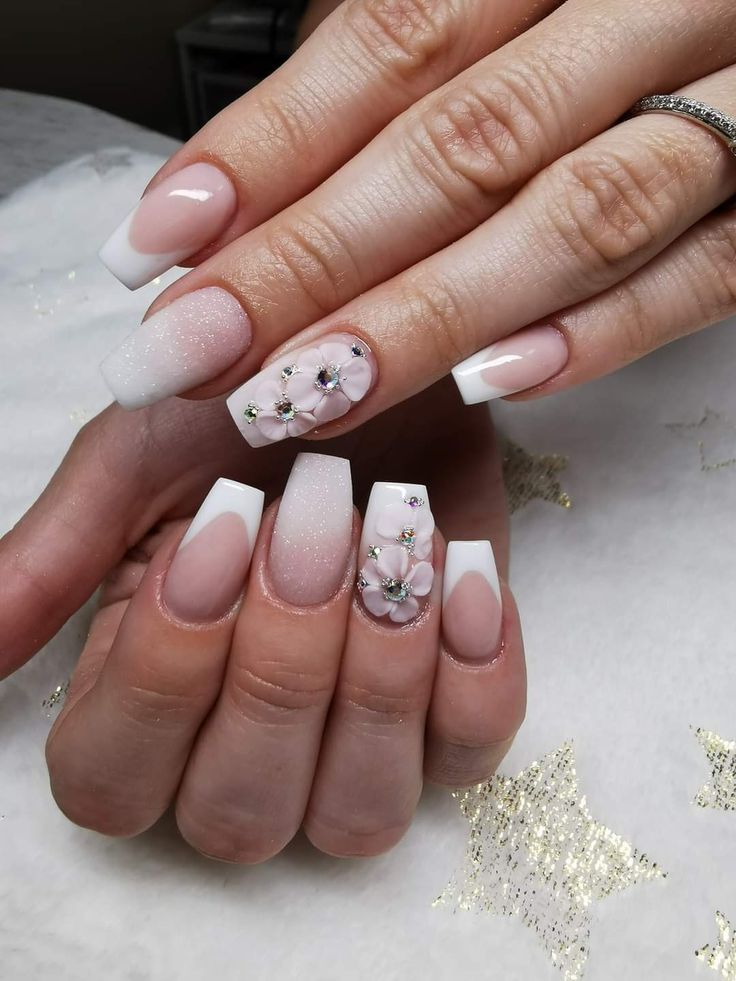 Sophisticated Nude and White Ombre Nail Design with Floral Gemstone Accents.