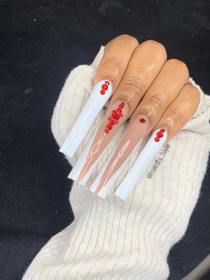 Elegant Glossy White and Nude Nail Design with Red Rhinestone Accents.